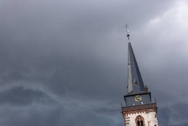 Dunkle Wolken über dem Kirchturm Dunkle Wolken eines Gewitters sind am Nachmittag am Himmel über dem Turm der katholischen Kirche St. Ursula zu sehen., Oberursel Hessen Deutschland