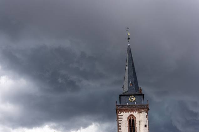 Dunkle Wolken über dem Kirchturm Dunkle Wolken eines Gewitters sind am Nachmittag am Himmel über dem Turm der katholischen Kirche St. Ursula zu sehen., Oberursel Hessen Deutschland