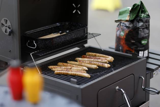 Grillwürste liegen auf einem Kohlegrill. Im Vordergrund Ketchup und Senf. (Themenbild, Symbolbild) Köln, 25.07.2023 NRW Deutschland Copyright: xChristophxHardtx