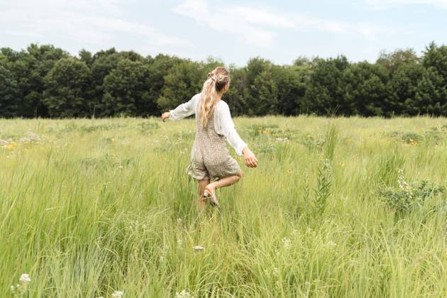 IMAGO Creative, Jahreszeit Sommer, Sommerferien A woman in a romper dancing in a field of grass Iowa City, Iowa, United States CR_VGMI230815-1231672-01 ,model released, Symbolfoto