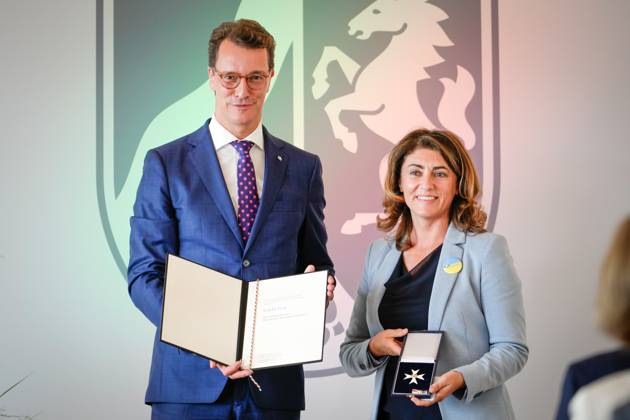 Verleihung des Verdienstorden des Landes Nordrhein-Westfalen Linda Mai aus Koeln Gruenderin des Verein Blau-Gelbes Kreuz mit Hendrik Wuest Ministerpraesident von Nordrhein-Westfalen mit dem Verdienstkreuz und der Urkunde bei der Verleihung des Verdienstorden des Landes Nordrhein-Westfalen in der Staatskanzlei in Duesseldorf, Düsseldorf, 22.08.2023 Duesseldorf Nordrhein-Westfalen Deutschland