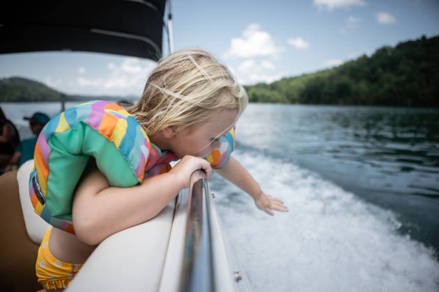 IMAGO Creative, Jahreszeit Sommer, Sommerferien Young child leaning over boat railing to touch wake on lake Cookeville, Tennessee, United States CR_WEKW23082878-1242351-01 ,model released, Symbolfoto