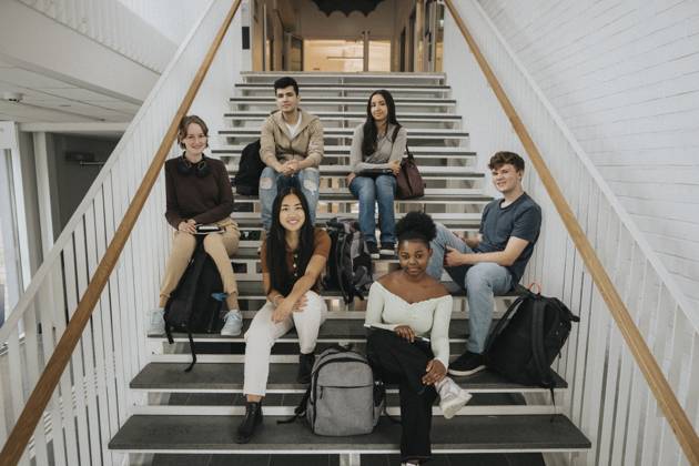 Portrait of happy multiracial male and female students sitting on staircase in university Sweden, Gothenburg, model released, property released Copyright: xMaskotx , MA103006 MA103006