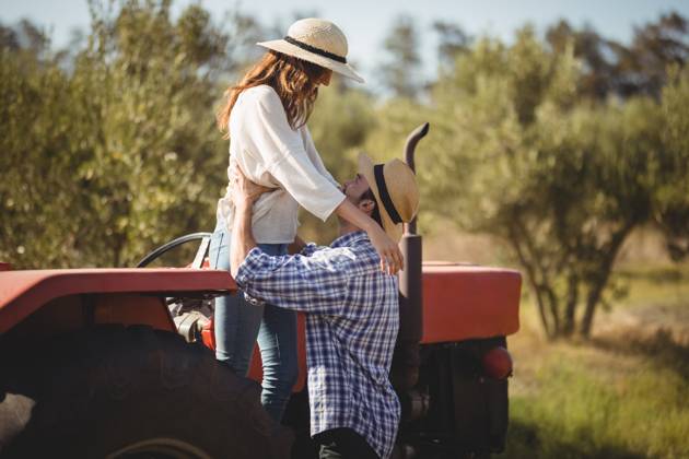 Young couple looking at each other while standing by tractor at olive farm, model released, , property released, , 29517002.jpg, RECORD DATE NOT STATED