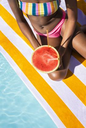 Young woman sitting with watermelon on sunny day model released, Symbolfoto, VRAF00183