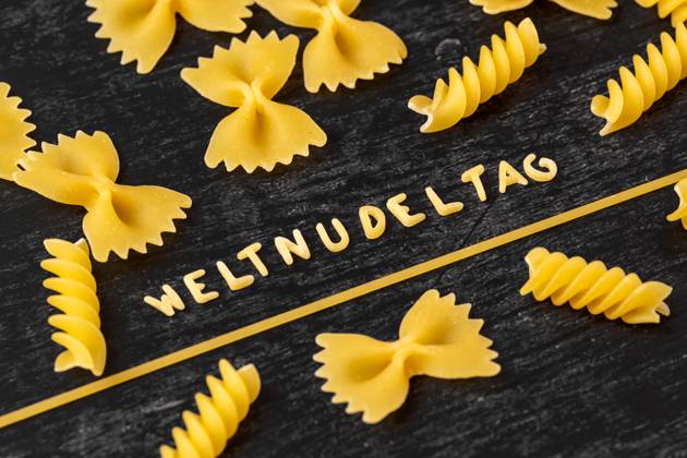 Weltnudeltag Wort aus Buchstaben Nudeln geformt inmitten von verschiedenen Nudel Sorten. Symbolbild Weltnudeltag am 25 Oktober
