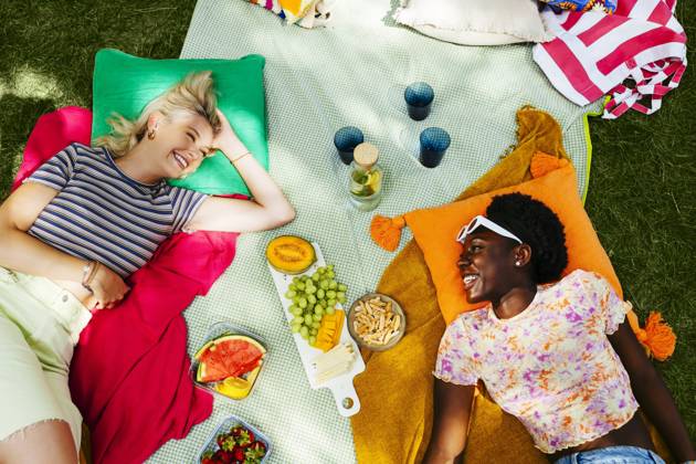 Smiling friends lying on picnic blanket in garden model released, Symbolfoto, EBSF03759