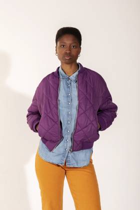 Young woman with hands in pockets standing against white background model released, Symbolfoto, VABF04419