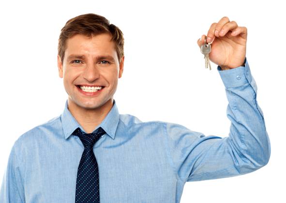 Portrait of smiling businessman holding keys isolated on white background Copyright: Crestock 32179459