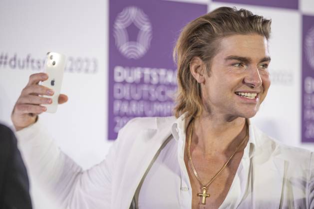 Influencer Jeremy Fragrance filmt sich selbst mit seinem Smartphone auf dem roten Teppich. DUFTSTARS 2023 - Deutscher Parfumpreis Verleihung des deutschen Parfumpreises DUFTSTARS durch die Fragrance Foundation am 16.11.2023, Rheinterrassen, Duesseldorf.