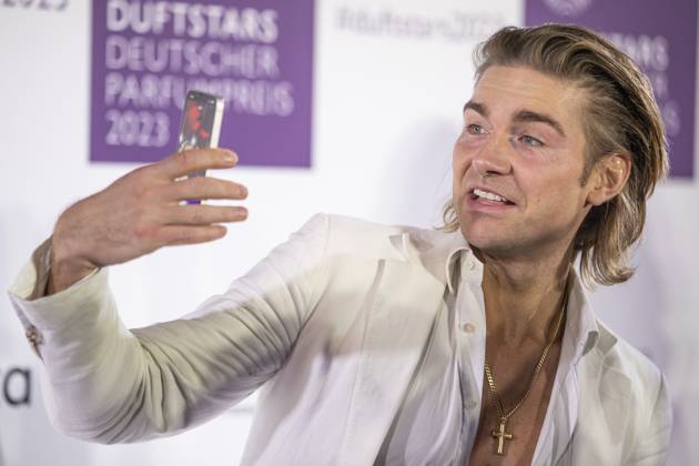 Influencer Jeremy Fragrance filmt sich selbst mit seinem Smartphone auf dem roten Teppich. DUFTSTARS 2023 - Deutscher Parfumpreis Verleihung des deutschen Parfumpreises DUFTSTARS durch die Fragrance Foundation am 16.11.2023, Rheinterrassen, Duesseldorf.