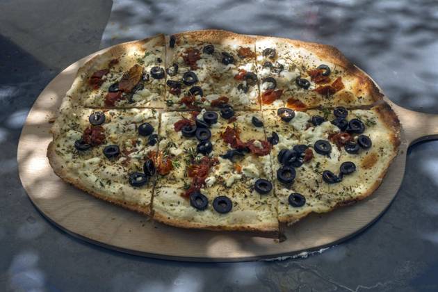 Flammkuchen mit getrockneten Tomaten, Schafskäse, Oliven und Schnittlauch auf einem Holzbrett serviert, Bayern, Deutschland, Europa Copyright: imageBROKER HelmutxMeyerxzurxCapellen iblmzc09837998.jpg