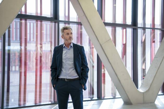 Thoughtful businessman standing with hands in pockets near columns model released, Symbolfoto property released, JOSEF21986