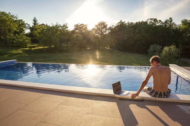 Freelancer sitting with laptop on poolside model released, Symbolfoto property released, MAMF02903