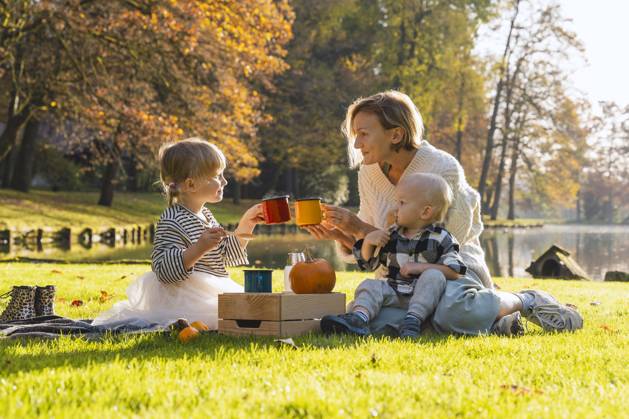 Smiling mother toasting cup with daughter near lake on sunny day model released, Symbolfoto, NDEF01360