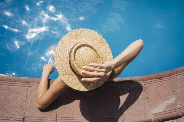 Woman wearing straw hat relaxing in pool on sunny day model released, Symbolfoto, YBF00280