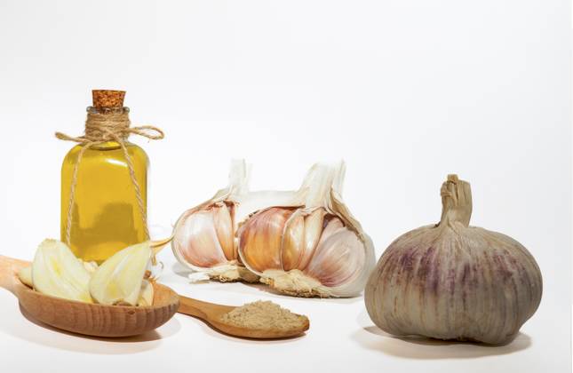 Ganzer, pulverisierter und gehackter Knoblauch auf weißem Hintergrund mit einer Glasflasche mit Olivenöl Copyright: imageBROKER/josexhernandezxantona ibxjhh09928767