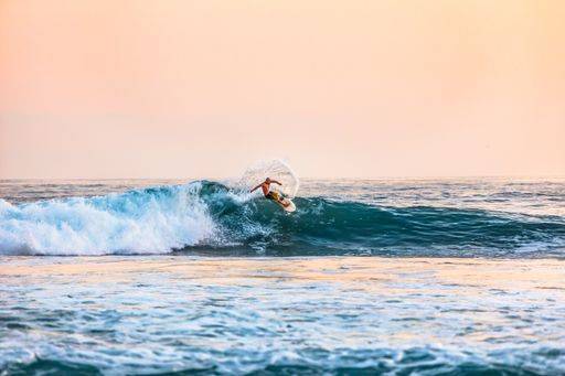 A shot of a male surfing on the sea during daytime 28305 RECORD DATE NOT STATED