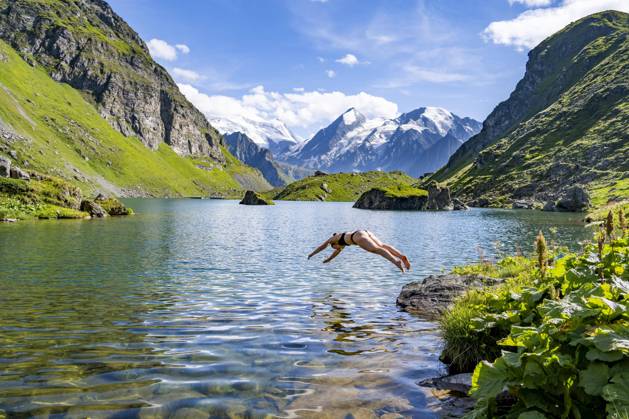 Hechtsprung, Junge Frau mit Bikini springt ins klare Wasser eines malerischen Bergsees, Lac de Louvie, Grand Combin, Walliser Alpen, Wallis, Schweiz, Europa