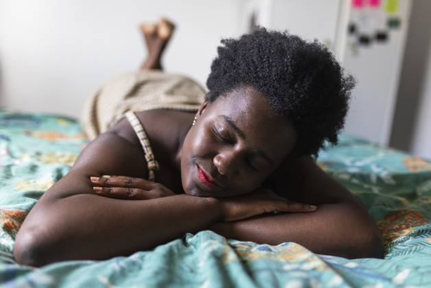 Young woman resting on bed in bedroom at home model released, Symbolfoto, WPEF07837