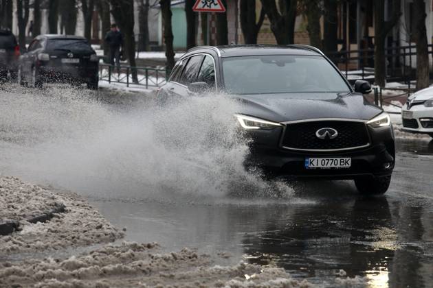 RECORD DATE NOT STATED VYSHNEVE, UKRAINE - JANUARY 04, 2024 - A car drives through a deep puddle on the street, Vyshneve, Kyiv region, north-central Ukraine Wintertime in Vyshneve  Copyright: xVolodymyrxTarasovx