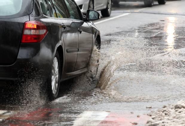 RECORD DATE NOT STATED VYSHNEVE, UKRAINE - JANUARY 04, 2024 - A car drives through a deep puddle on the street, Vyshneve, Kyiv region, north-central Ukraine Wintertime in Vyshneve  Copyright: xVolodymyrxTarasovx