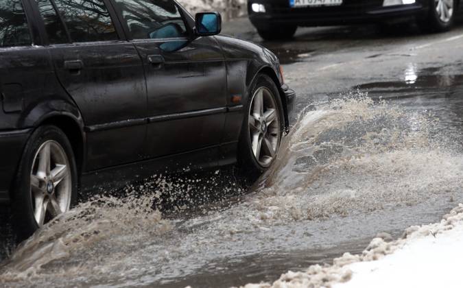 RECORD DATE NOT STATED VYSHNEVE, UKRAINE - JANUARY 04, 2024 - A car drives through a deep puddle on the street, Vyshneve, Kyiv region, north-central Ukraine Wintertime in Vyshneve  Copyright: xVolodymyrxTarasovx