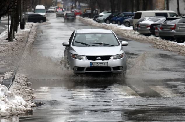 RECORD DATE NOT STATED VYSHNEVE, UKRAINE - JANUARY 04, 2024 - A car drives through a deep puddle on the street, Vyshneve, Kyiv region, north-central Ukraine Wintertime in Vyshneve  Copyright: xVolodymyrxTarasovx