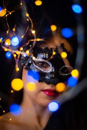 IMAGO Creative, Gesellschaft, Fasching A vertical shot of a Hispanic young woman with a carnival mask and bokeh lights 1417722 ,model released, Symbolfoto RECORD DATE NOT STATED