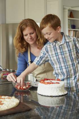 Caucasian mother and son decorating cake in kitchen Christiansburg, Virginia, USA, 07.04.2015, model released, TTBB_BLD158590.jpg, 40-44 years, 6-7 years, assistance, baking, bonding, boy, boys, cake, caucasian, childhood, choice, Christiansburg, color image, cooking, cooperation, decorating, dessert, domestic kitchen, domestic life, elementary age, family with one child, food and drink, happy, helping, indoors, learning, looking down, love, mature adult, mature women, mother, one parent, people, photography, red hair, selective focus, smiling, son, standing, strawberry, teaching, teamwork, together, two people, United States, vertical, Virginia, woman, working together, 2, 40-45, 40-50, 40s, 40s, 45-50, 50-55, 50-60, 55-60, adoring, adorn Copyright: xJeffxGreenoughx