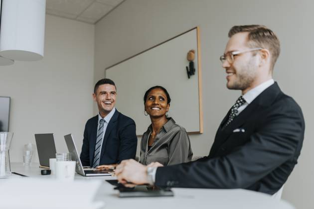 Smiling colleagues looking at businessman while sitting in board room Sweden, Gothenburg, model released, property released Copyright: xMaskotx , MA106420 MA106420