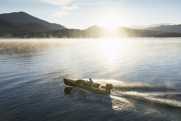 USA, New York, Lake Placid, Man in motorboat on Lake Placid , 22.09.2016, model released, TTBB_ti0027_00716.jpg, Lake, Caucasian Ethnicity, Motorboat, Outdoors, Day, Getting Away From It All, Summer, Vacations, Tranquility, Horizontal, Sun, Scenics, Fog, Mountain Range, On The Move, Travel Destinations, Morning, Lake Placid, Leisure Activity, Wake - Water, Solitude, Reflection, Speed, One Person, One Senior Man Only, 65-69 Years, USA, New York Copyright: xChrisxHackettx