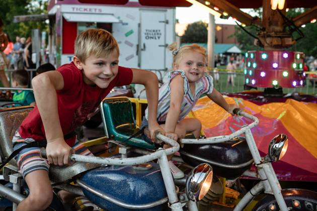 IMAGO Creative, Jahreszeit Sommer, Sommerferien Kids having fun riding carnival ride at summer festival Cobden, Illinois, United States CR_WEKW2402055D-1347888-01 ,model released, Symbolfoto