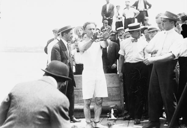 Harry Houdini being handcuffed before being nailed into a crate and lowered into New York Bay, 1912 (b w photo) 1766225 Harry Houdini being handcuffed before being nailed into a crate and lowered into New York Bay, 1912 (b w photo); Private Collection; (add.info.: Houdini, born Erik Weisz (1874-1926) in Budapest was nailed into a packing case said to contain iron weights, which he escaped through a trap.). Copyright: xBridgemanxImagesx 1766225