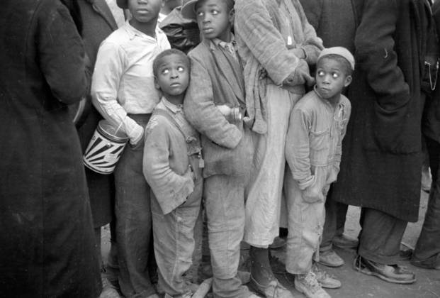 Black american in the lineup for food at mealtime in the camp for flood refugees, Forrest City, Arkansas, 1937 (b w photo) 3666453 Black american in the lineup for food at mealtime in the camp for flood refugees, Forrest City, Arkansas, 1937 (b w photo) by Evans, Walker (1903-75); Private Collection; (add.info.: Photograph taken for the U.S. Resettlement Administration: a New Deal U.S. federal agency that, between April 1935 and December 1936, relocated struggling urban and rural families to communities planned by the federal government.). Copyright: xBridgemanxImagesx 3666453