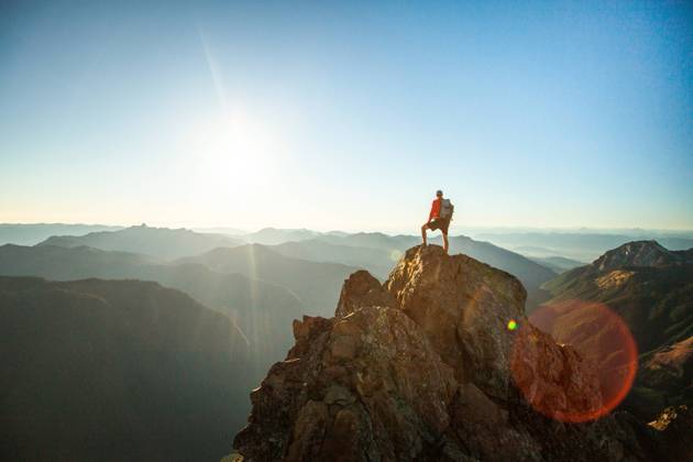 successful hiker wearing backpack stands on mountain summit, sunset Glacier, Washington, United States CR_JDIP240227-1346412-01 ,model released, Symbolfoto