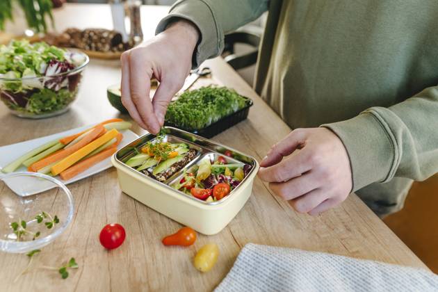 IMAGO Creative, Food, Trend, Meal Prep Man garnishing microgreen over vegetarian food in lunch box model released, Symbolfoto property released, YTF01683