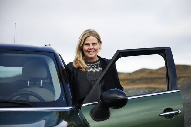 Young blond woman standing next to small green car , model released Copyright: xJohnerxImagesx , johner2408734