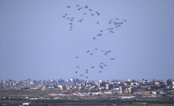 Bilder des Jahres 2024, News 03 März News Themen der Woche KW11 News Bilder des Tages United States Air Force C-130 drops humanitarian aid by parachute over the central, northern Gaza Strip as seen from inside southern Israel on March 10, 2024. This photo shows three planes-full of aid as it descends to Gaza. The USA and other countries continue to drop food and other humanitarian aid supplies to Palestinians in dire need in the Gaza Strip on the first day of the month-long Moslem holiday of Ramadan. As reports continue of fighting between Israeli forces and Hamas inside Gaza.  ISR20240311002 JimxHollander