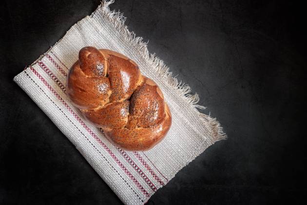 IMAGO Creative: Food, Mohn A loaf of white bread on a linen napkin On a linen napkin is a loaf of white bread in the shape of a plait with poppy seeds and a crisp crust. Presented on a dark background, top view, copy space Copyright: xZoonar.com GalinaxxTolochkox 16272917
