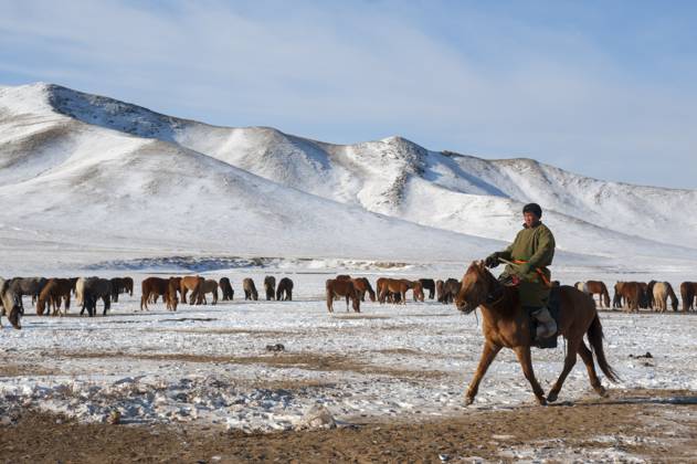 Herders relocating a herd of horses to a winter pasture near Ulaanbaatar, Mongolia. Herders relocating a herd of horses to a winter pasture near Ulaanbaatar, Mongolia., Credit:Wolfgang Kaehler Avalon 0534925872