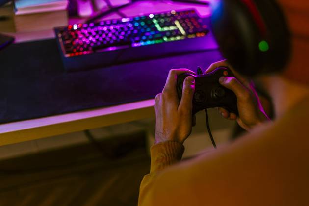 IMAGO Creative, Lifestyle, Gaming Gaming influencer playing video games using controller at home model released, Symbolfoto property released, EGHF00835