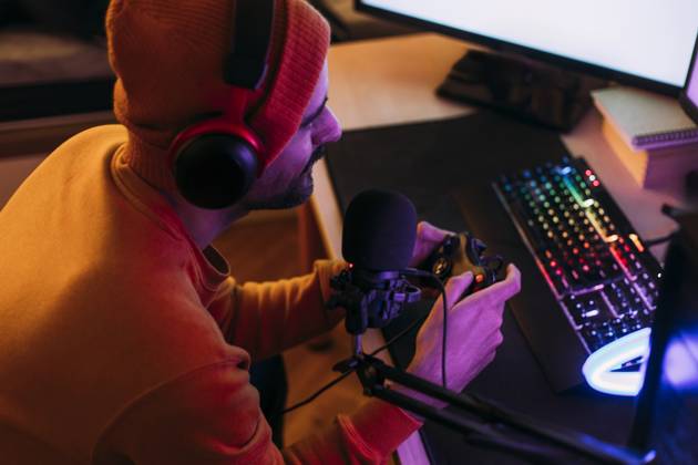 IMAGO Creative, Lifestyle, Gaming Gaming influencer wearing wireless headphones and playing video games at home model released, Symbolfoto property released, EGHF00836