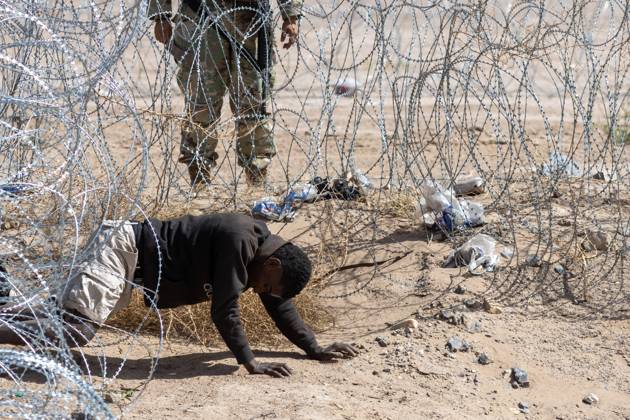 Bilder des Jahres 2024, News 03 März News Themen der Woche KW12 March 24, 2024: A man crawls under the barbed wire after attempting to cross the border, and a Texas National Guard agent orders him to return to Mexico - ZUMAp241 20240324_zip_p241_010 Copyright: xDavidxPeinadox