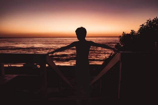 Silhouette of boy with the ocean and sunset in the background United States, California, San Diego CR_CHDO24032266-1361199-01 ,model released, Symbolfoto