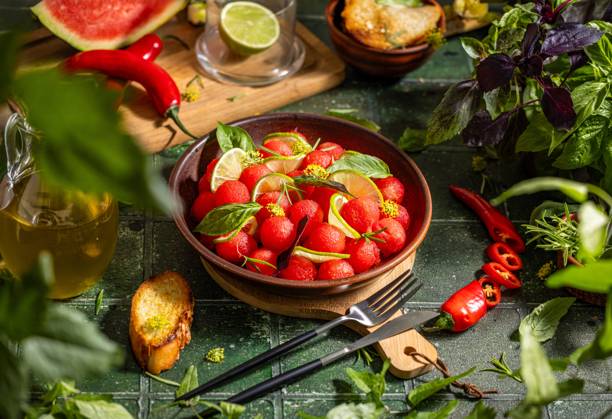 Spicy salad of fresh watermelon balls with basil, lime, rosemary and fennel, topping with olive oil Spicy salad of fresh watermelon balls with basil, lime, rosemary and fennel, topping with olive oil on dark green table surface with sunny light Copyright: xZoonar.com VictoriaxKondysenkox(ArtSvitlyna)x 20788051
