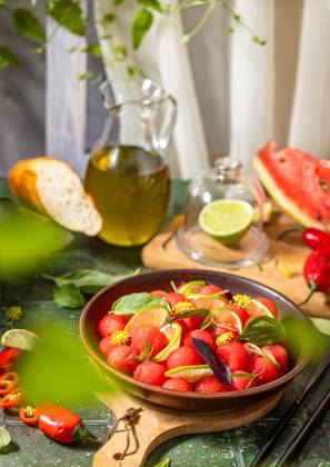 Spicy salad of fresh watermelon balls with basil, lime, rosemary and fennel, topping with olive oil Spicy salad of fresh watermelon balls with basil, lime, rosemary and fennel, topping with olive oil on dark green table surface with sunny light Copyright: xZoonar.com VictoriaxKondysenkox(ArtSvitlyna)x 20788072