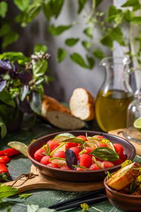 Spicy salad of fresh watermelon balls with basil, lime, rosemary and fennel, topping with olive oil Spicy salad of fresh watermelon balls with basil, lime, rosemary and fennel, topping with olive oil on dark green table surface with sunny light Copyright: xZoonar.com VictoriaxKondysenkox(ArtSvitlyna)x 20788143