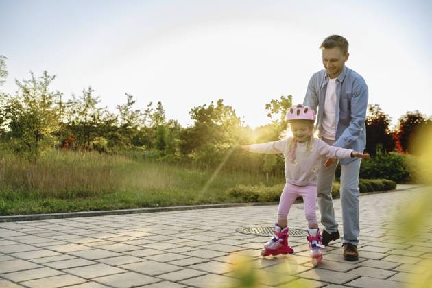 Daughter learning to roller skate with father on footpath model released, Symbolfoto, NSTF00044
