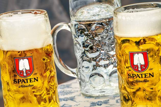 Alkohol oder alkoholfrei? zwei Maß Bier und ein Mineralwasser, München, Mai 2024 Deutschland, München, Mai 2024, Alkohol oder Alkoholfrei?, zwei Maß Bier und ein Mineralwasser stehen auf einem Biertisch, Maß Bier, Helles, Spaten, Münchner Bier, auf einem Volksfest, Bayern, bayerisch,